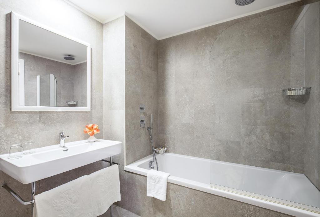 a bathroom with a sink and a bath tub at Hotel Caparena in Taormina