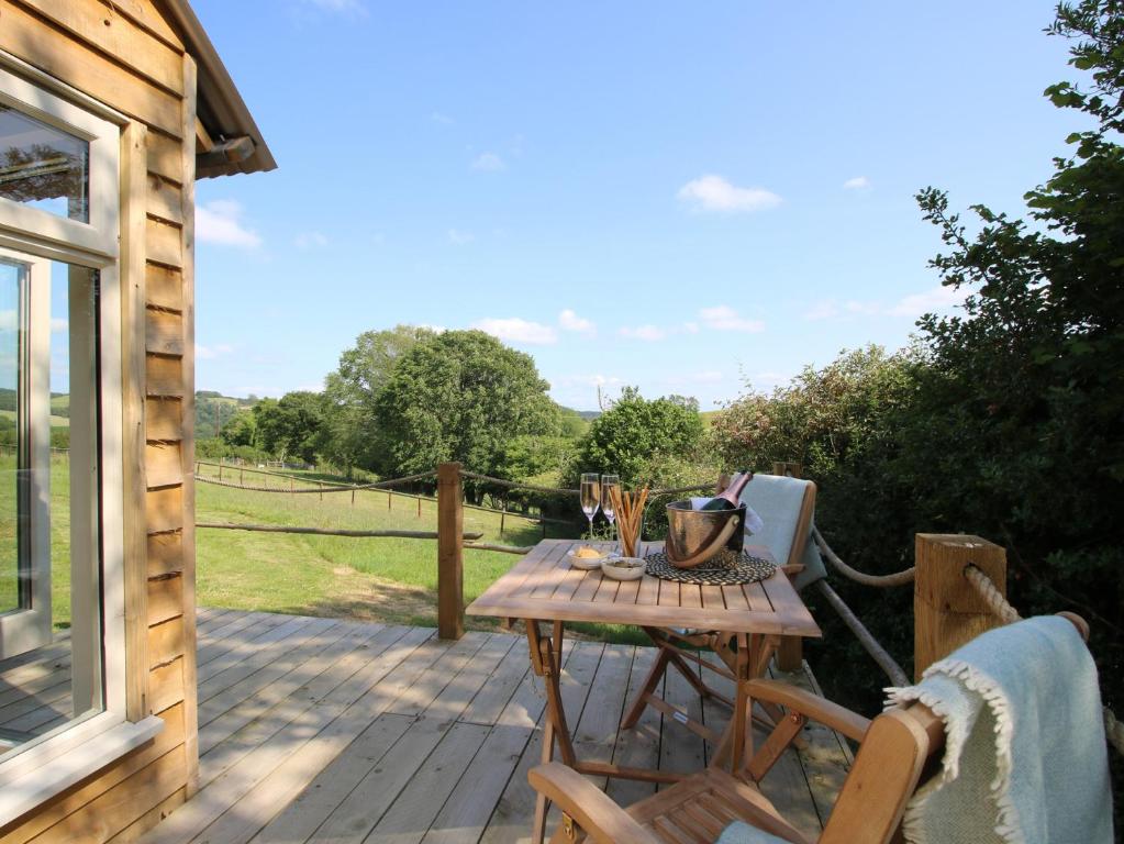 a wooden deck with a table and chairs on it at Swallows Nest in Bucknell