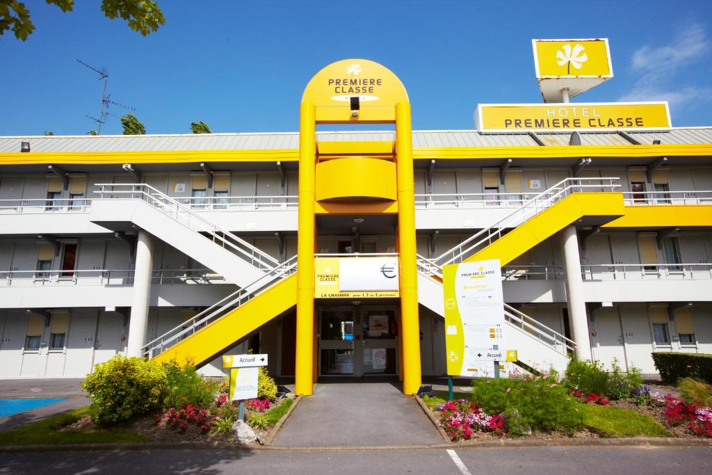 un grand bâtiment avec un grand bâtiment jaune dans l'établissement Première Classe Epinay Sur Orge Savigny Sur Orge, à Épinay-sur-Orge