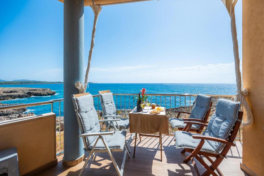 a balcony with chairs and a table and the ocean at Vista Fábula in S'Illot