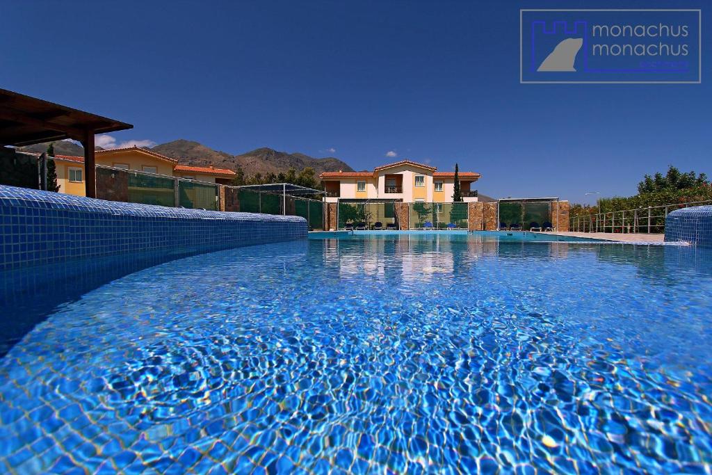 a swimming pool in front of a house at Monachus Monachus in Frangokastello