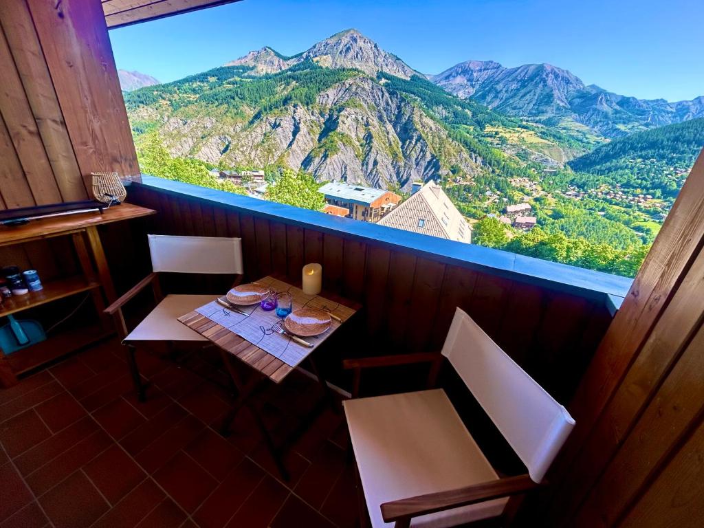 una mesa y sillas con vistas a la montaña en Duplex avec vue exceptionnelle parking et wifi gratuit, en Allos