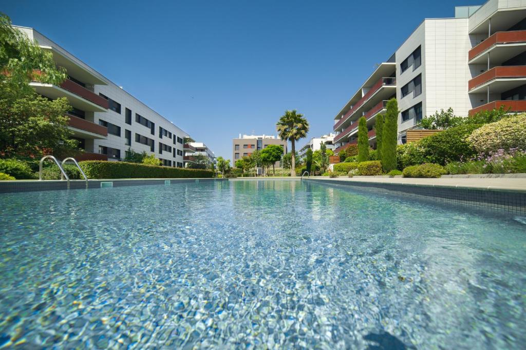 ein Pool vor einigen Apartmentgebäuden in der Unterkunft Luxury Apartment in Sitges City in Sitges