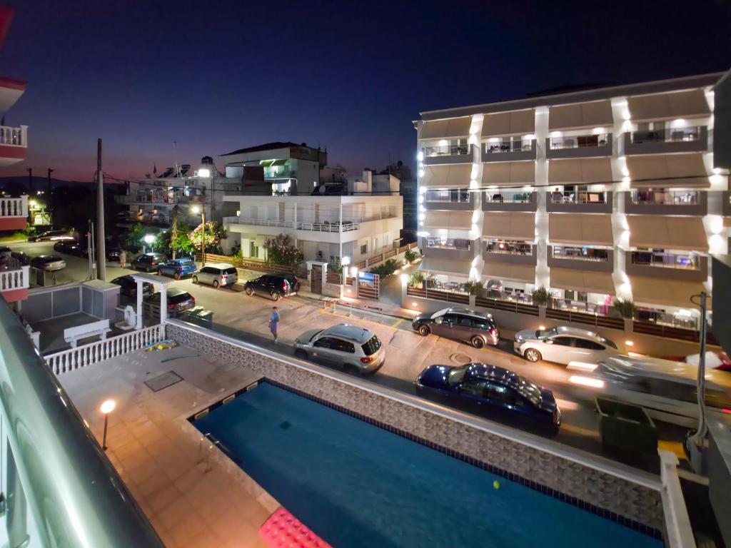 a pool in front of a building at night at APOLLON Suites by SDR in Paralia Katerinis