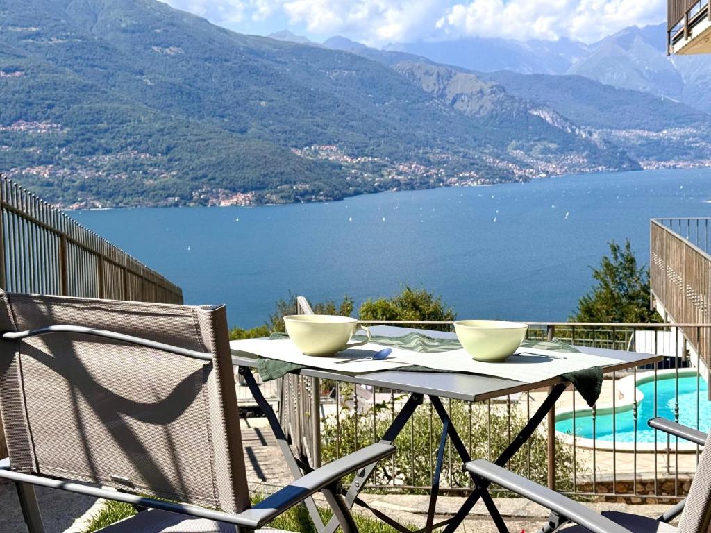 een tafel en stoelen op een balkon met uitzicht op een meer bij Casa Juliette in Bellano
