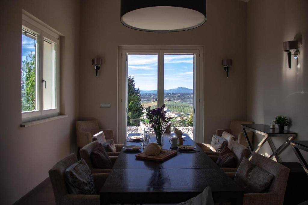 ein Esszimmer mit einem Tisch und einem großen Fenster in der Unterkunft Casa Maiella by Rentbeat in Città Sant'Angelo