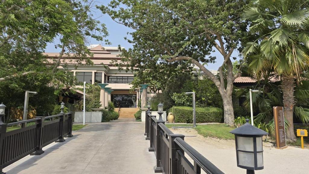 Stunning 1BR at Anantara Sea Views Palm Jumeirah في دبي: ممشى امام مبنى به شجرة
