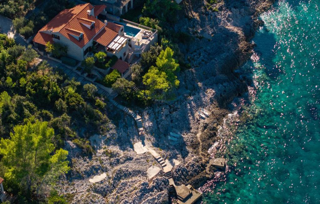 una vista aerea di una casa su una collina vicino all'acqua di Villa Stavros by Villas Guide a Blato