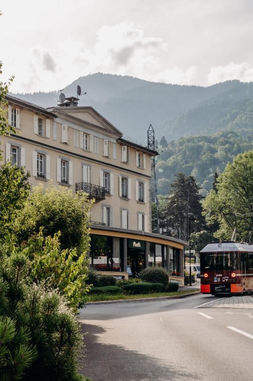 un bus passant devant un grand bâtiment dans une rue dans l'établissement PlanB - Living Saint-Gervais - 250m des Remontées Mécaniques, à Saint-Gervais-les-Bains