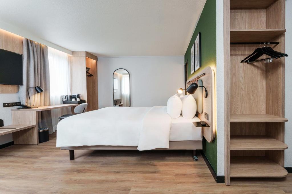 タッサン・ラ・ドゥミ・リュンヌにあるCampanile PRIME - Lyon Ouest Tassinの部屋にある大きな白いベッドのある寝室
