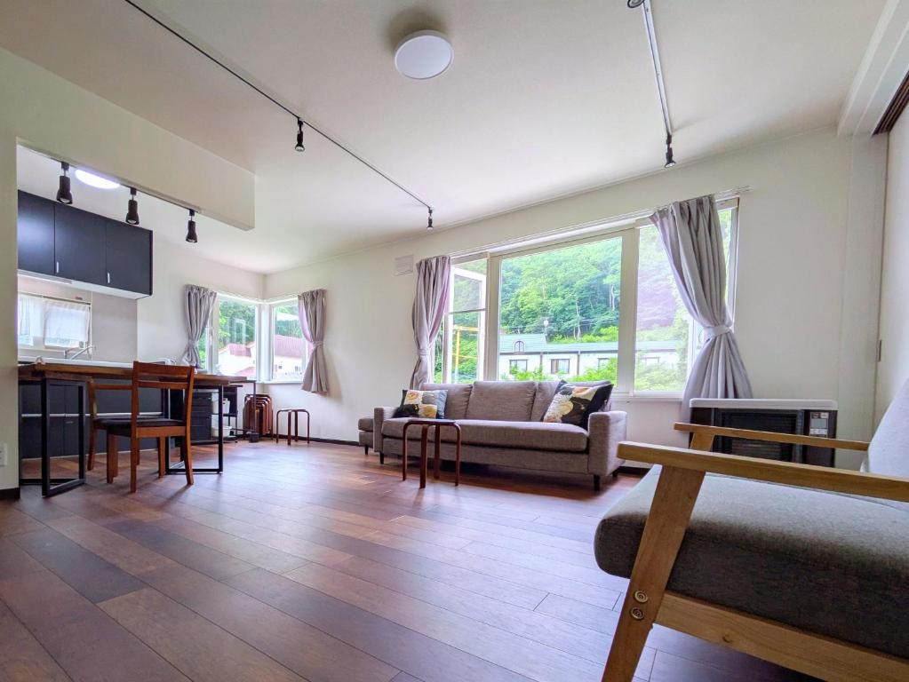 una sala de estar con un sofá y una mesa en Plazmastay OTARU, en Otaru