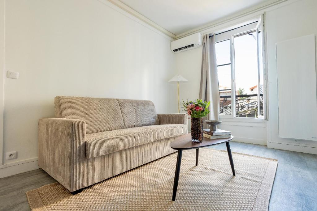 una sala de estar con un sofá y una mesa en Appartement Unique , rue du 14 juillet, en Le Pré-Saint-Gervais
