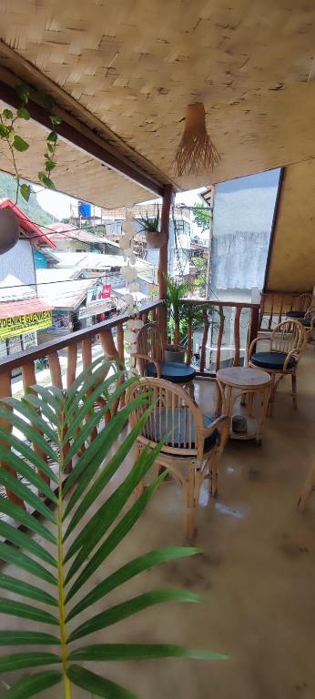 a room with chairs and tables and windows at Picado House in El Nido