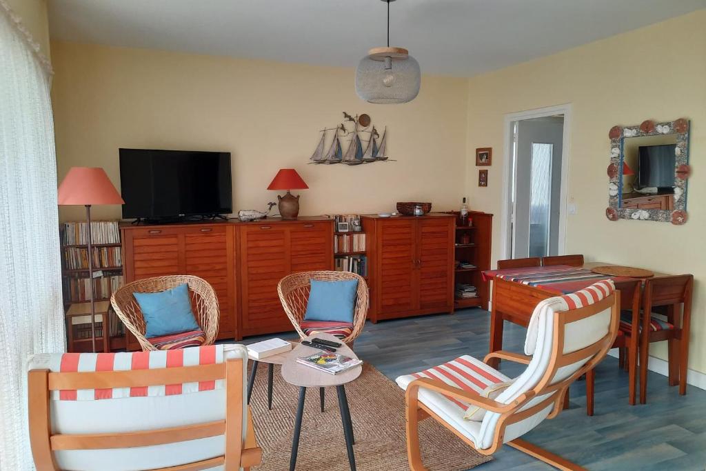 - un salon avec des chaises, une table et une télévision dans l'établissement 42m overlooking the pine forest and near the sea, à Les Sables-dʼOlonne