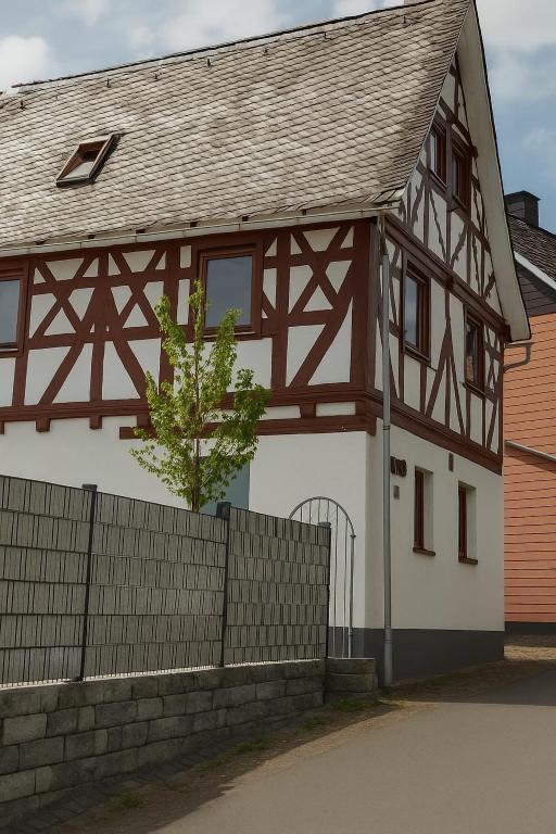 a white and brown house with a fence at Ferienhaus Lubentiusblick Limburg in Limburg an der Lahn
