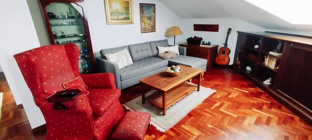 een woonkamer met een bank en een stoel bij El Ático de Frida in Vigo
