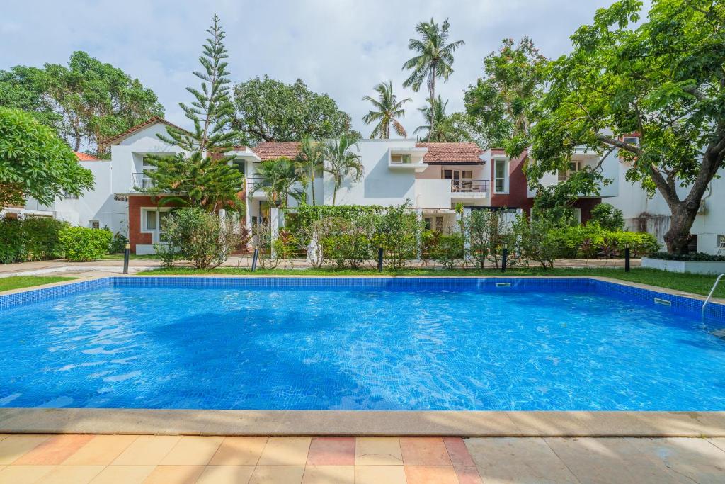 una imagen de una piscina frente a una casa en Villa Bella Vista, Candolim, en Candolim