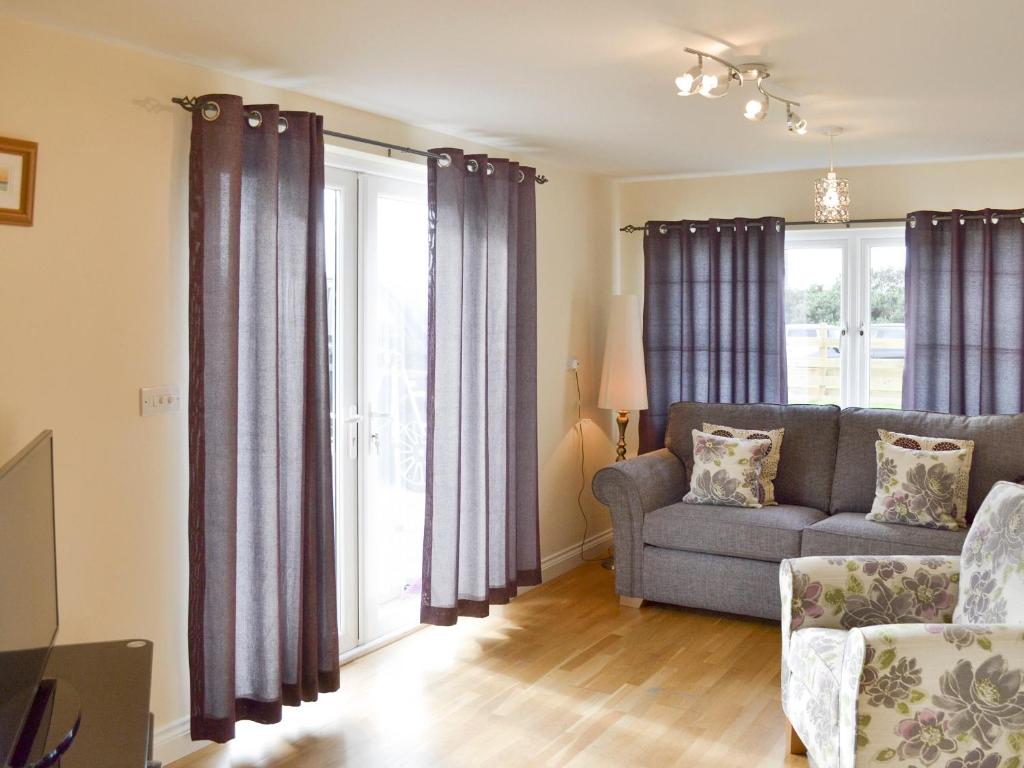 a living room with a couch and a window at Lindum Leys in Saint Hilary