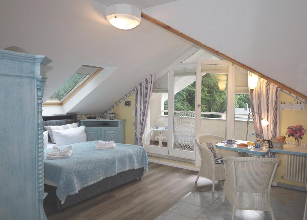 a bedroom with a bed and a table and a balcony at Villa Strandperle, App 18 - nur 20m zum Strand, TOPLAGE in Binz