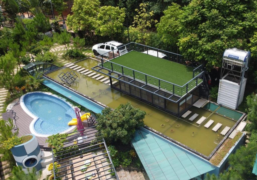 an aerial view of a house with a tennis court in the water at The Honey House Sóc Sơn in Sóc Sơn