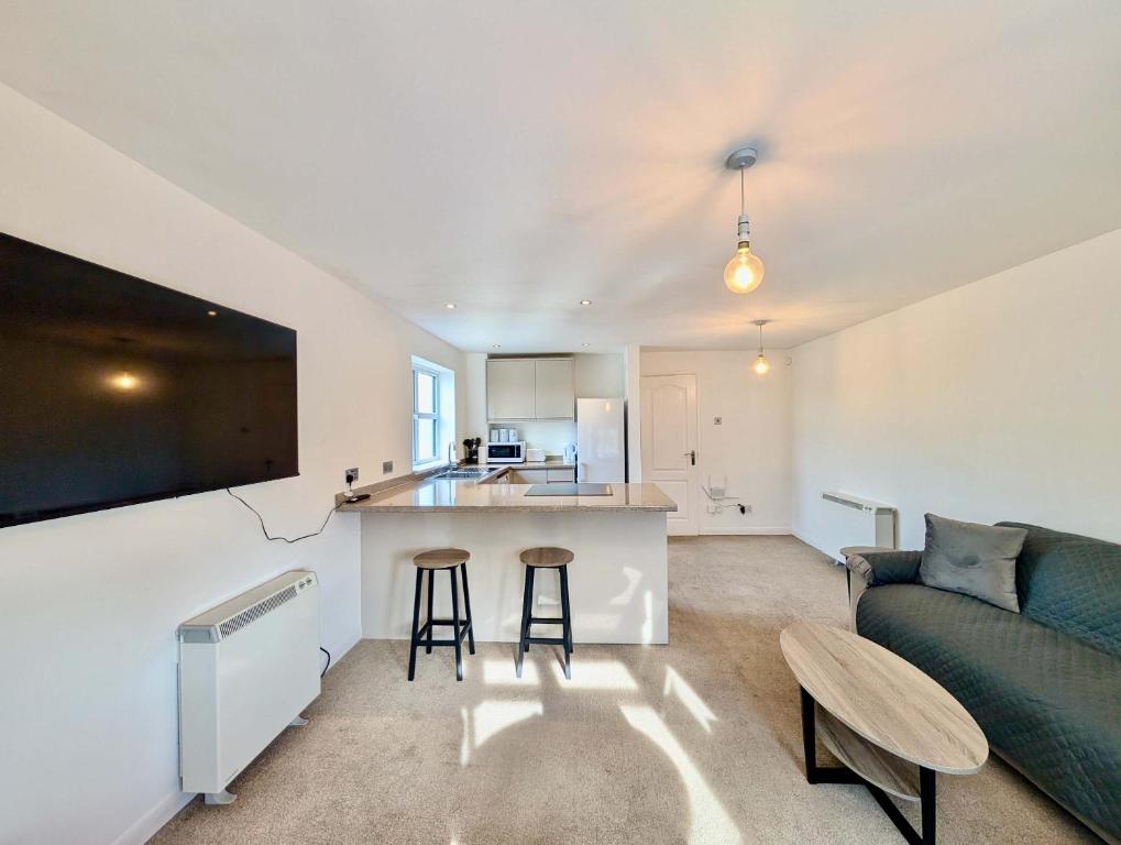 a kitchen and living room with a couch and a table at Charming and Modern 1-Bedroom Flat in Slough