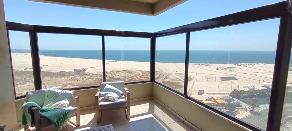 a balcony with two chairs and a view of the beach at Buarcos&Sea Accommodation - Cristal Mar - Your Panoramic Ocean View Retreat in Figueira da Foz