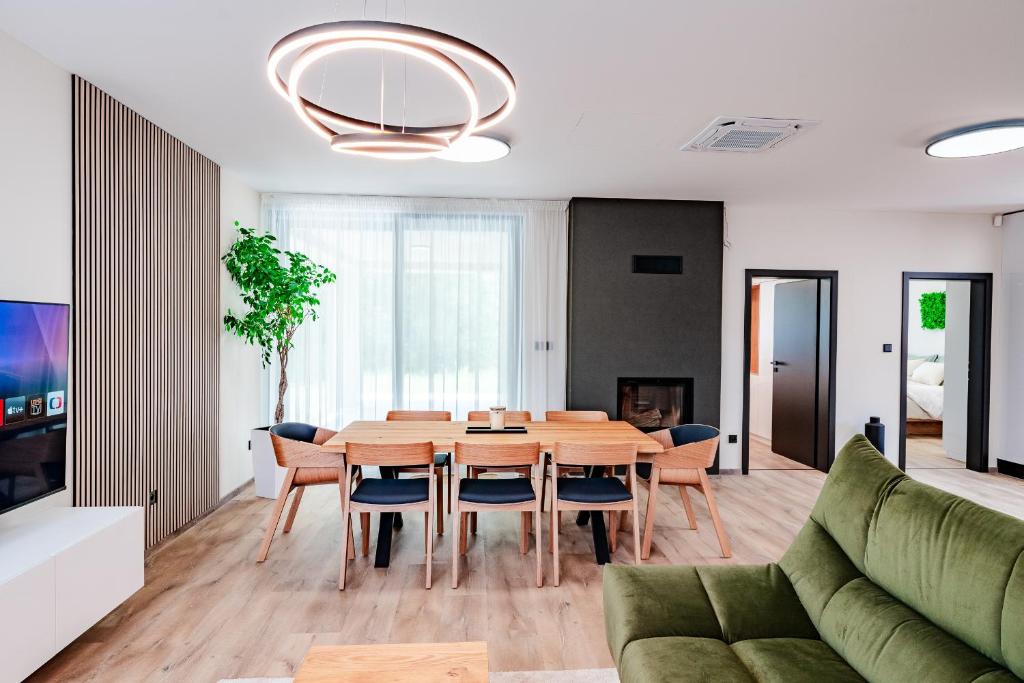 a living room with a wooden table and a green couch at Domček pri golfe in Skalica