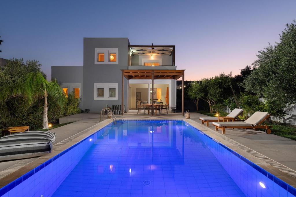 a swimming pool in front of a house at Villa Olvia in Gennadi