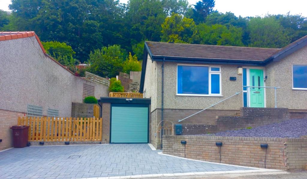 una casa con un garage con una porta blu di Cosy little house on Great Orme a Llandudno
