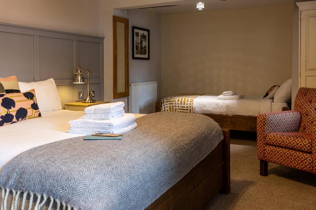 a hotel room with a bed and a chair at The Crown & Horns in Newbury