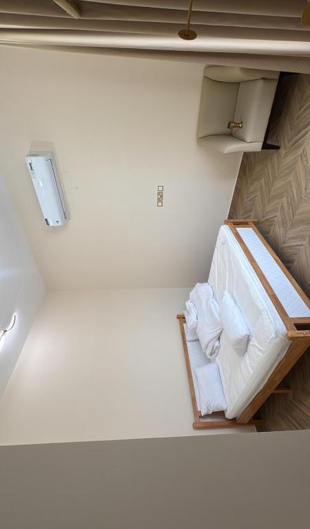 a room with a bed with white sheets and towels at Bain Al Qimam in Hatta
