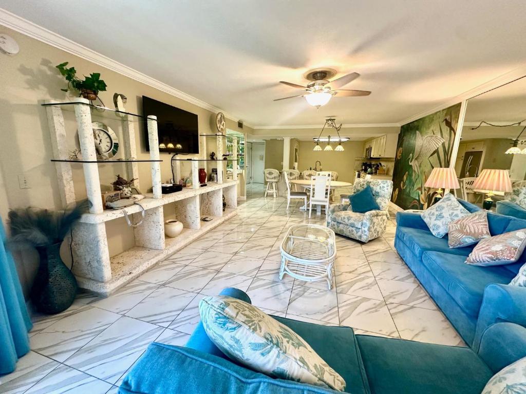 a living room with blue couches and a dining room at Paradise Found Cayo Hueso in Key West
