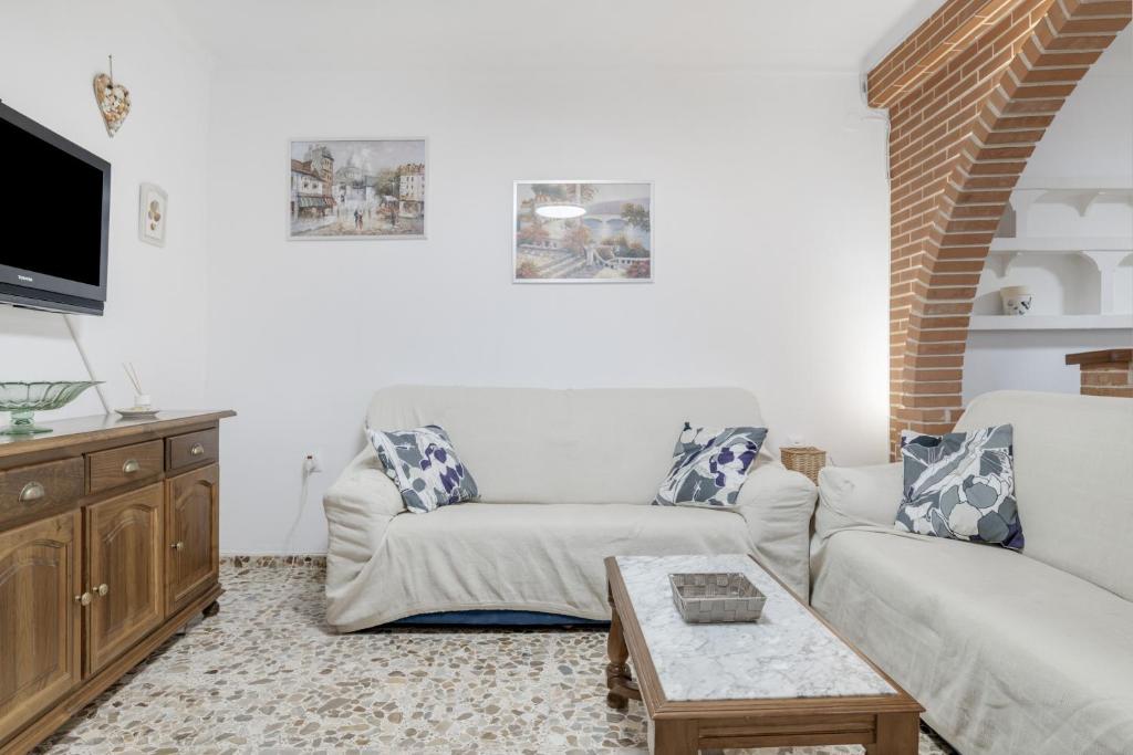 ein Wohnzimmer mit einer Couch und einem Couchtisch in der Unterkunft Casa Grande en el Centro de Conil in Conil de la Frontera