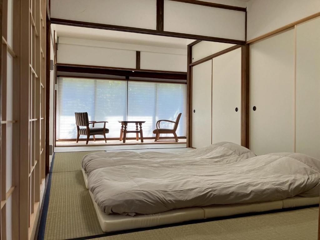 Ένα ή περισσότερα κρεβάτια σε δωμάτιο στο 和宿520ゴーニマル緑青