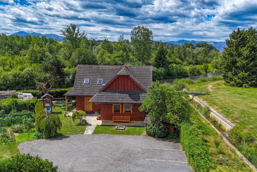 an aerial view of a log house with a yard at River Cottage Bešeňová in Bešeňová