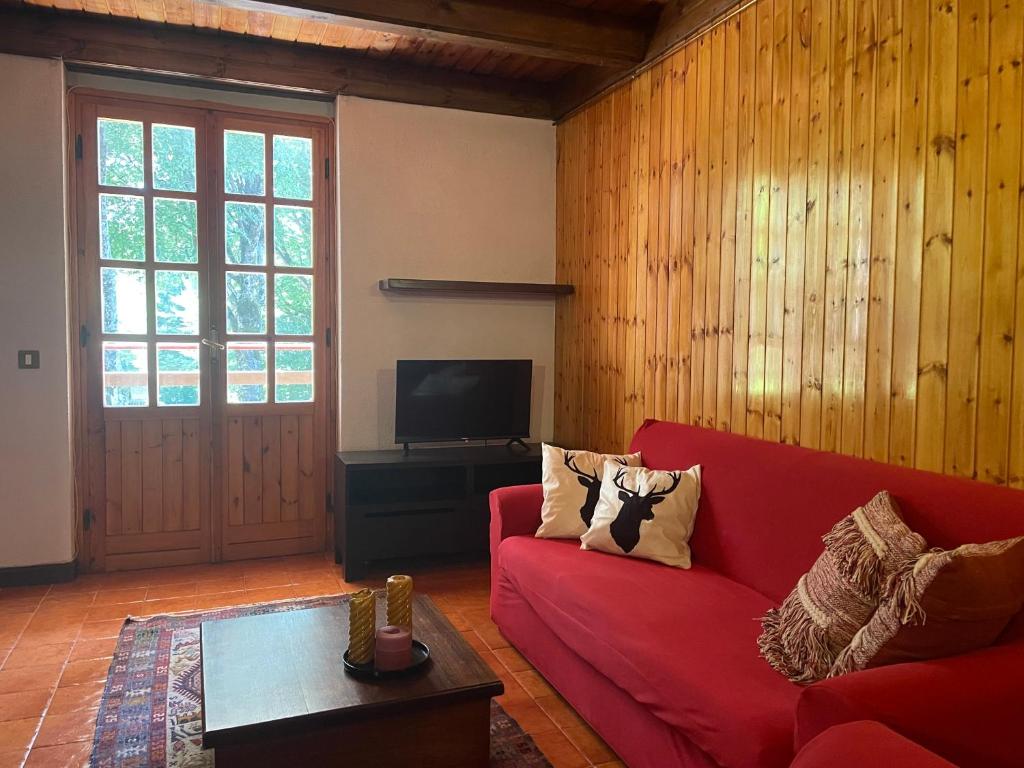 a living room with a red couch and a tv at La Pilli a Monte Livata in Livata