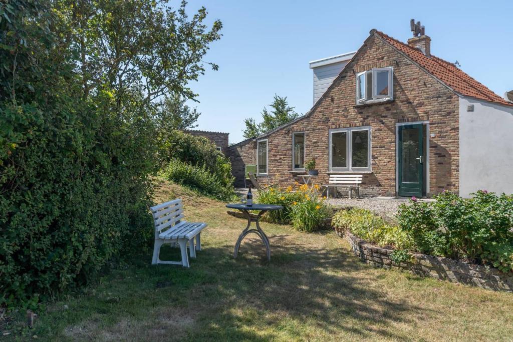 a bench and a table in front of a house at Hello Zeeland - Vakantiewoning PJ Eloutstraat 13 in Domburg