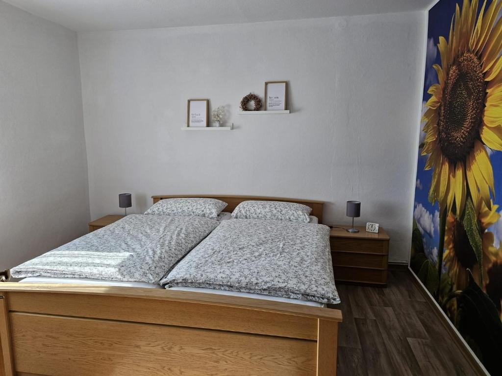 a bedroom with a bed with a sunflower mural at Ferienwohnung Hof Segberg in Langenberg