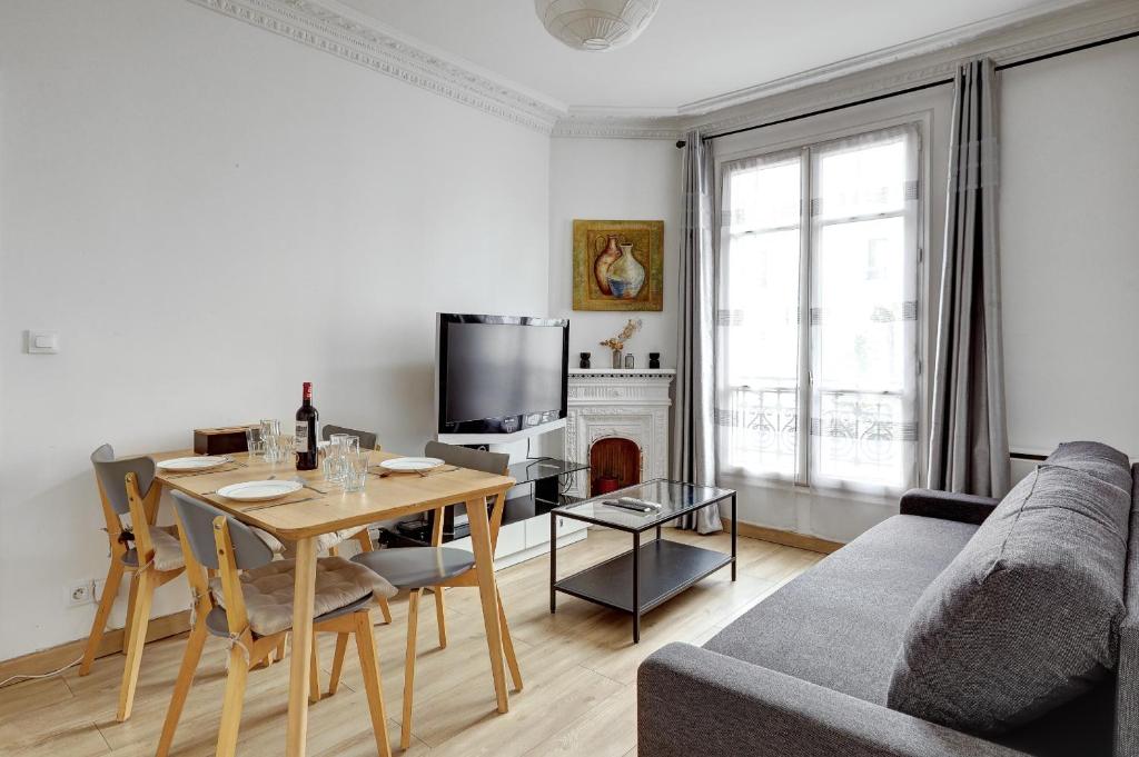 un salon avec une table et une télévision dans l'établissement 121 - 4 Personnes Jeux Olympiques Stade de France, à Aubervilliers