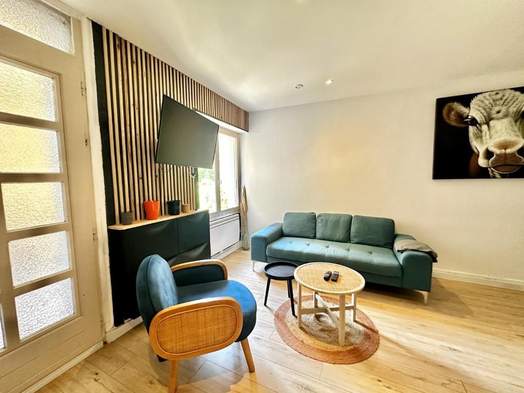 - un salon avec un canapé et une vache sur le mur dans l'établissement La maison de Joséphine, à 200m de la plage, à Saint-Aubin-sur-Mer