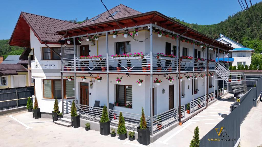 a white building with flowers on the balconies at VAiAs Aparts in Tîrgu Neamţ