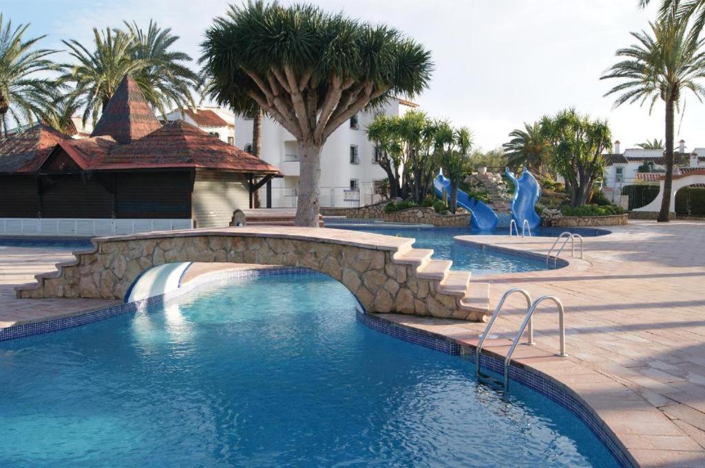 a swimming pool with a bridge in a resort at Appartement El Palmar Denia in Denia
