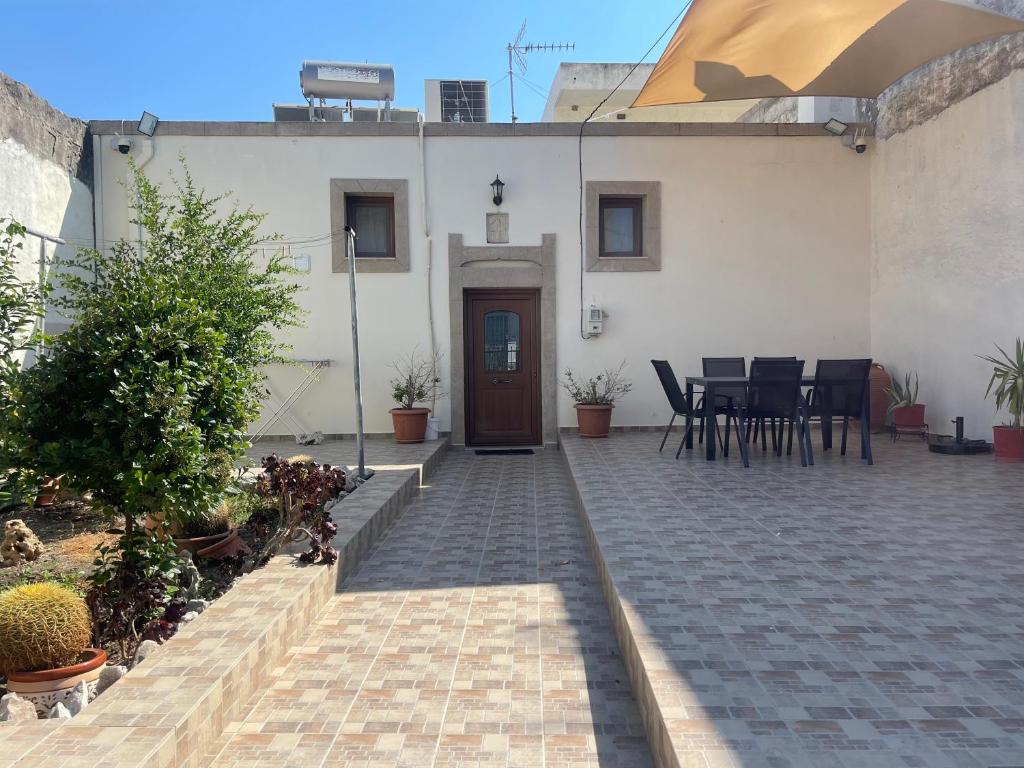 ein Haus mit einer Terrasse mit Tisch und Stühlen in der Unterkunft Kamara Cottage - Traditional Stone House in Malona Village