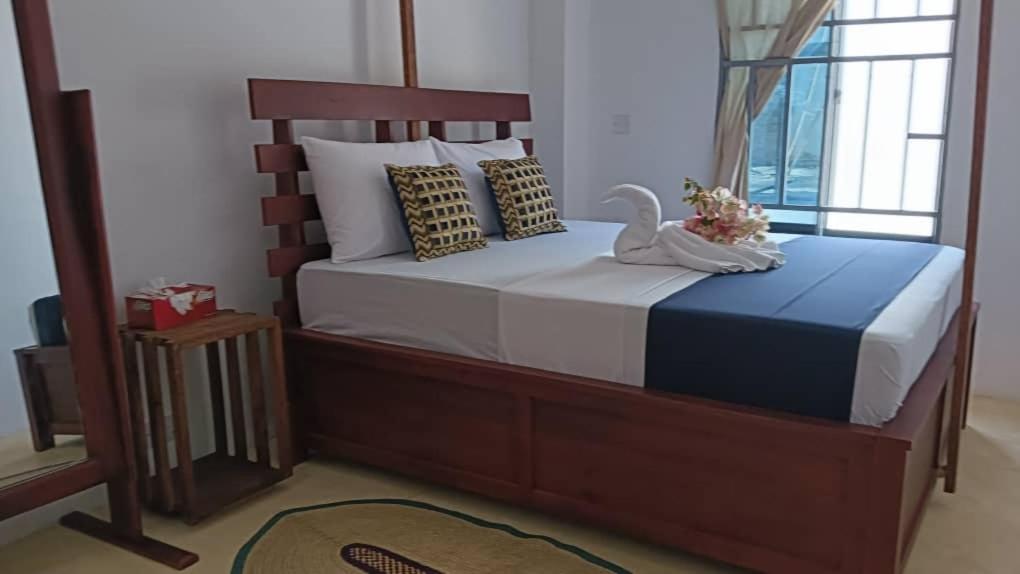 a bedroom with a bed with a swan on it at Pahali in Bwejuu
