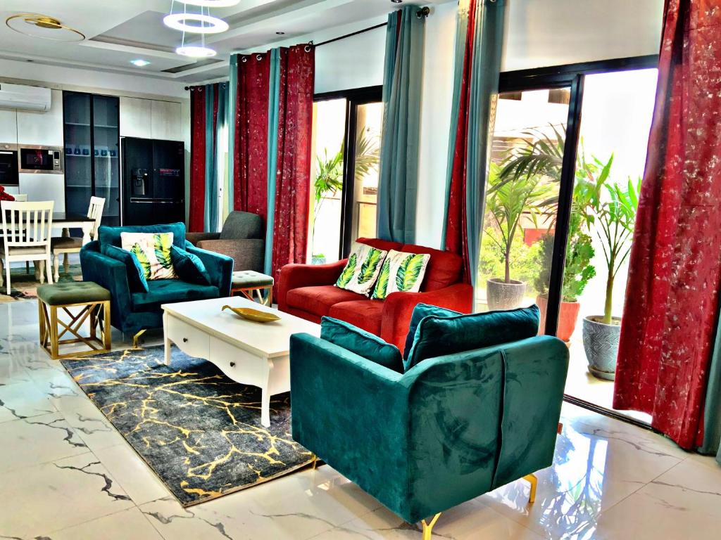 Una sala de estar con dos sillas y una mesa. en Appartement meublé de rêve, en Dakar