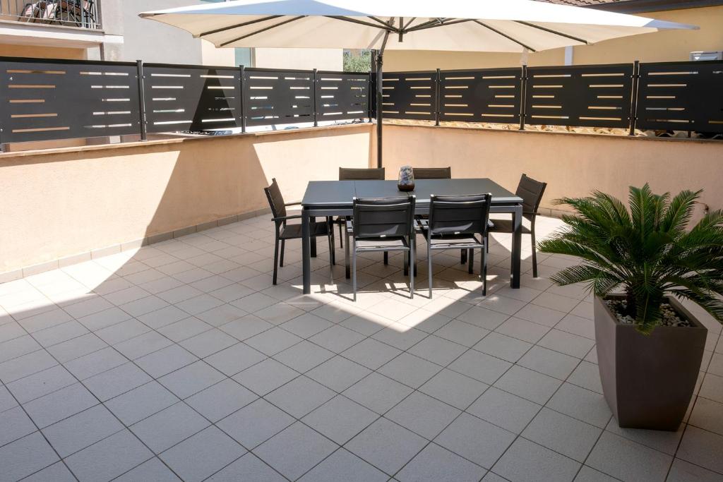 a patio with a table and chairs and an umbrella at Beltà di Spello in Spello