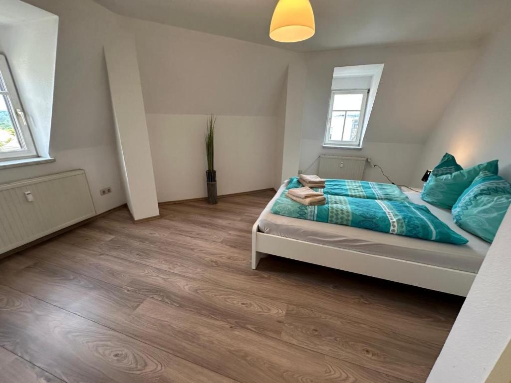 une chambre avec un lit avec des oreillers bleus dans l'établissement Appartment mit Aussicht "Grün", à Plauen