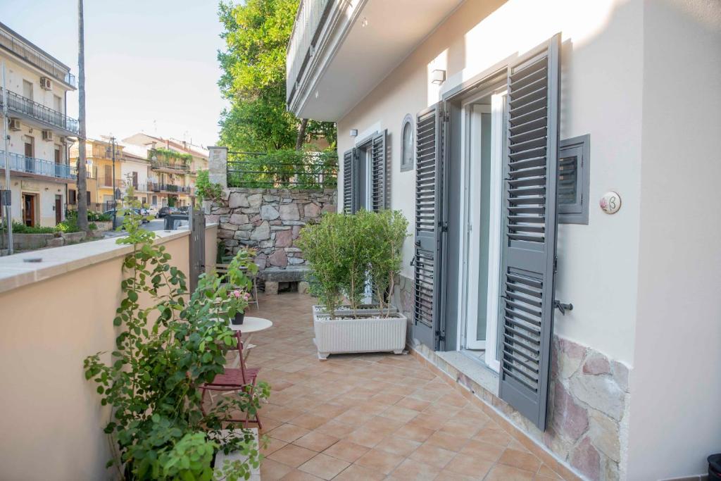 an outdoor patio with a table and shutters on a building at La Magnolia in Centola
