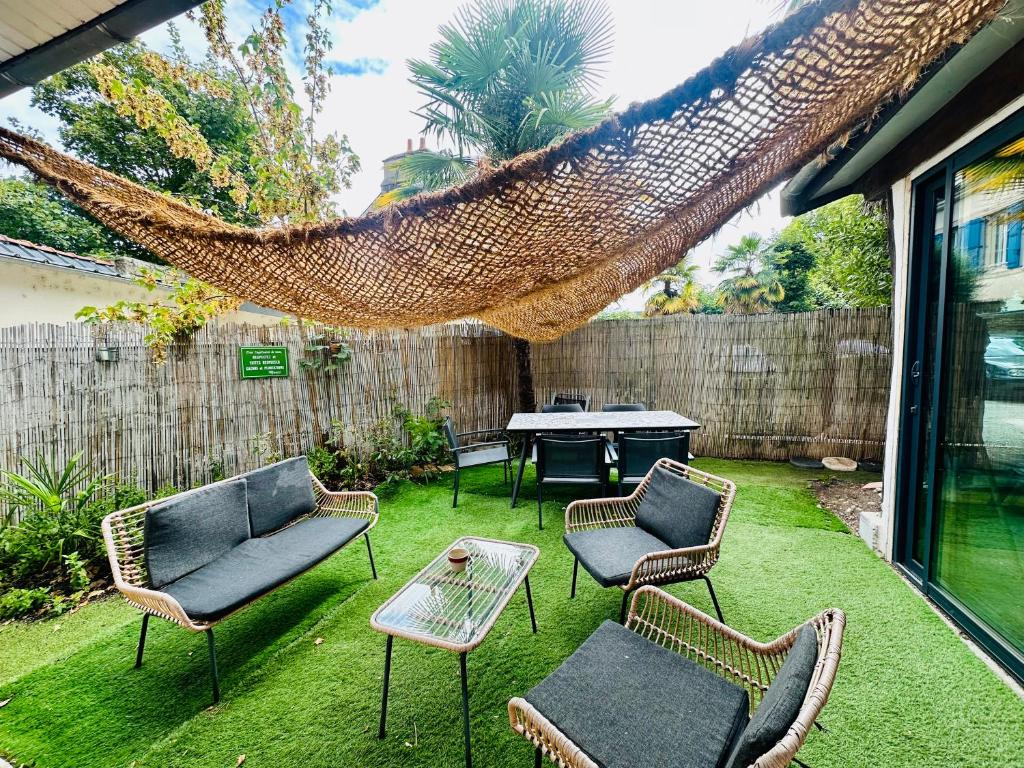d'une terrasse avec des chaises, une table et un hamac. dans l'établissement Maison bohème centre ville avec parking, à Orléans