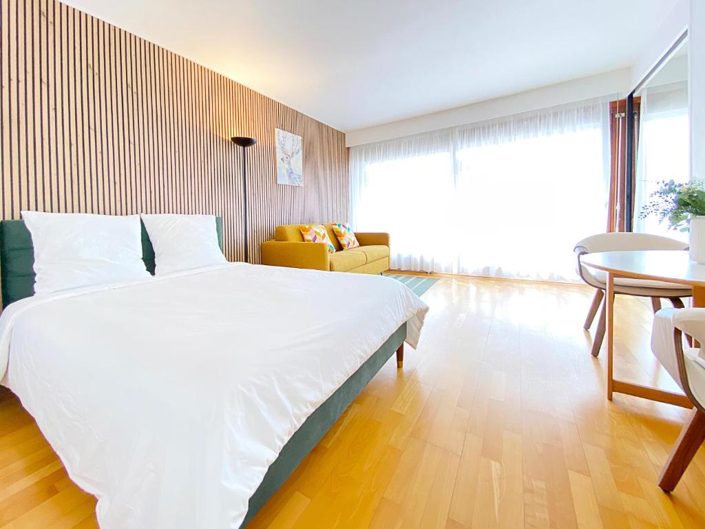 une chambre avec un grand lit blanc et un canapé dans l'établissement Cosy flat with the view of Eiffel Tower, à Paris